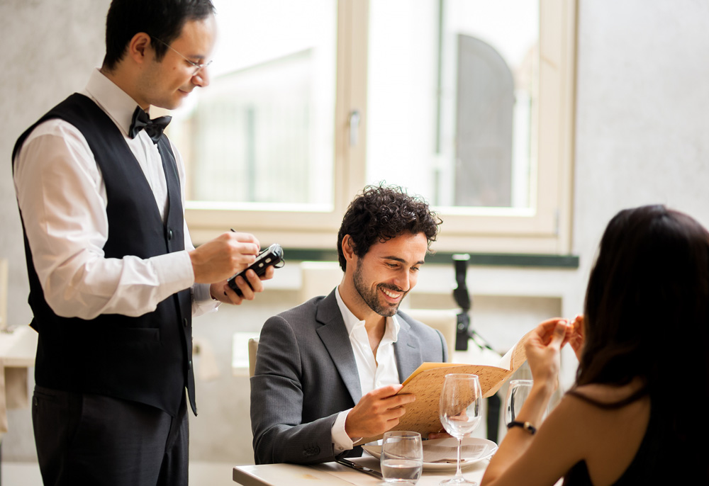 Waiter with couple making order
